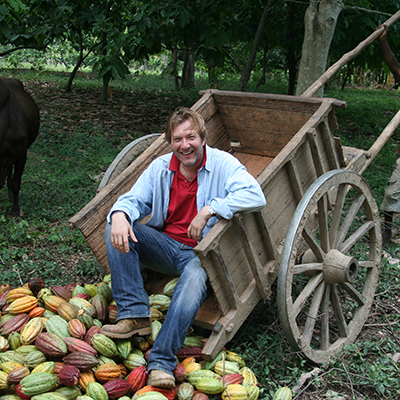 bertil on his farm with cocoa pods