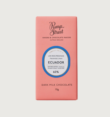 Picture of pump street ecuador dark milk bar on a grey background. pink packaging with a blue circle around its label