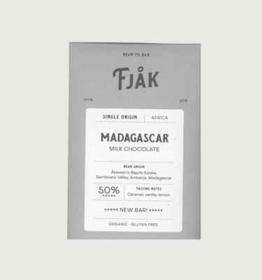 Fjak's 50% madagascar milk bar on a grey background. The bar is grey, with a white label with black writing on the front.