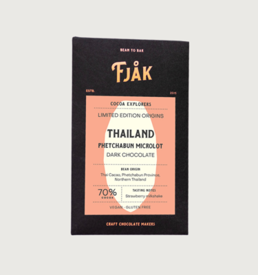 Picture of fjak's thailand microlot dark bar on a grey background. The bar is black, with a peach coloured square that has the outline of a cocoa bean in the middle, in white.