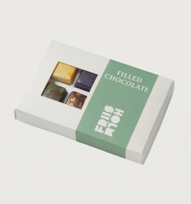 A box of 8 truffles from Friis Holm on a grey background.
