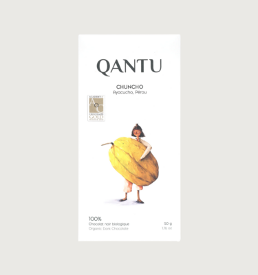 Qantu's chuncho 100% bar on a grey background. The bar is white, with black text and a cartoon lady holding a giant yellow cacao pod.