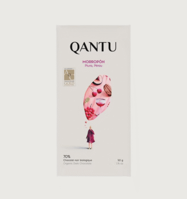 A qantu bar on a grey background. The packaging is white and pink