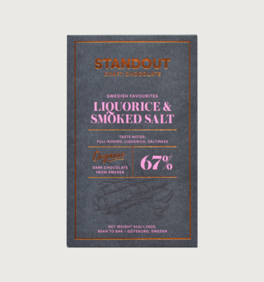 Standout's Liquorice and smoked sea salt bar on a grey background. The bar is grey, with a bronze border, and baby pink writing.