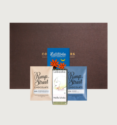 Picture of our stocking filler gift box on a grey background. with taster bars from Pump street and zotter, and a taster bar from Latitude, with a brown cocoa runners gift box.