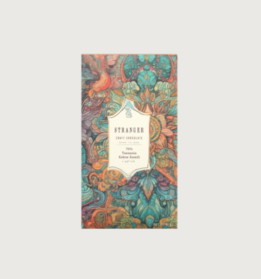 Stranger's kokoa Kamili tanzania dark bar on a grey background. The bar is teal, red, orange, and yellow, with the colours swirling around in an intricate pattern. The label is white, with black writing.